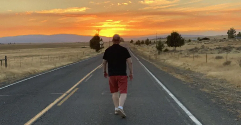 Mark Middleton walking an open road at sunset in Oregon